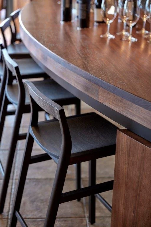 Longitude 131 custom furniture in Tasmanian Blackwood - Nathan Day Design, close-up angled view of curved bar counter with wine glasses