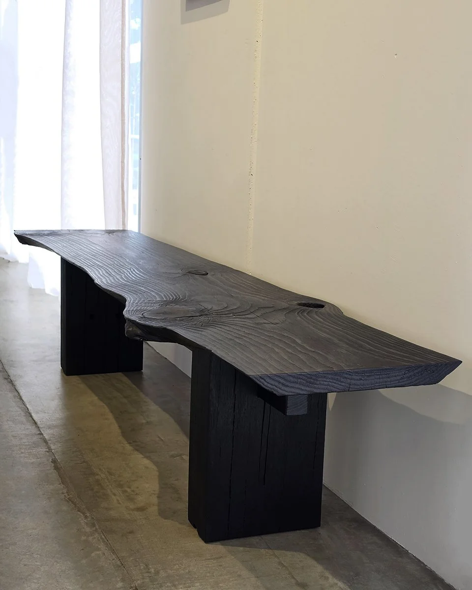 Burnside Bench installed in a home entry beside a light-filled window, showing knot holes and grain in the scorched timber finish - Nathan Day Design