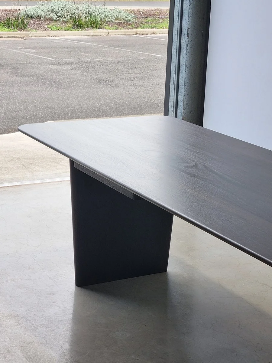 Morey Desk in ebonised Jarrah, full angled side view in outdoor courtyard setting - Nathan Day Design
