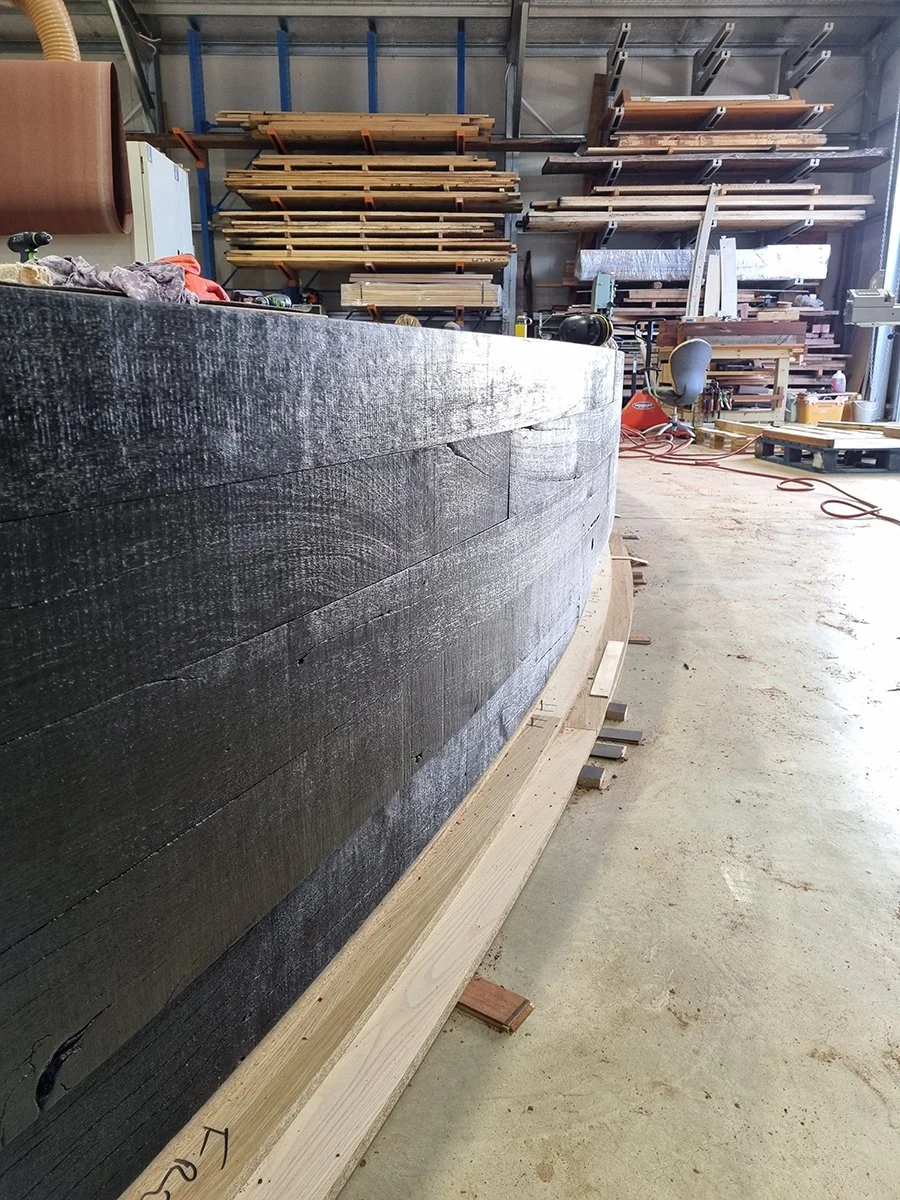 Reception Counter - One The Esplanade in scorched timber - Nathan Day Design, close-up long side view of scorched black textured curve