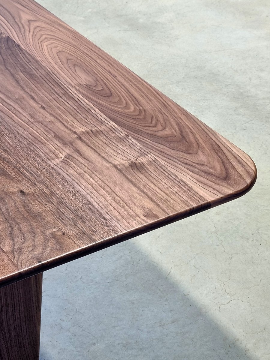 Overhead detail of the Morey Table's Walnut tabletop showing its rounded corner and flowing grain - Nathan Day Design