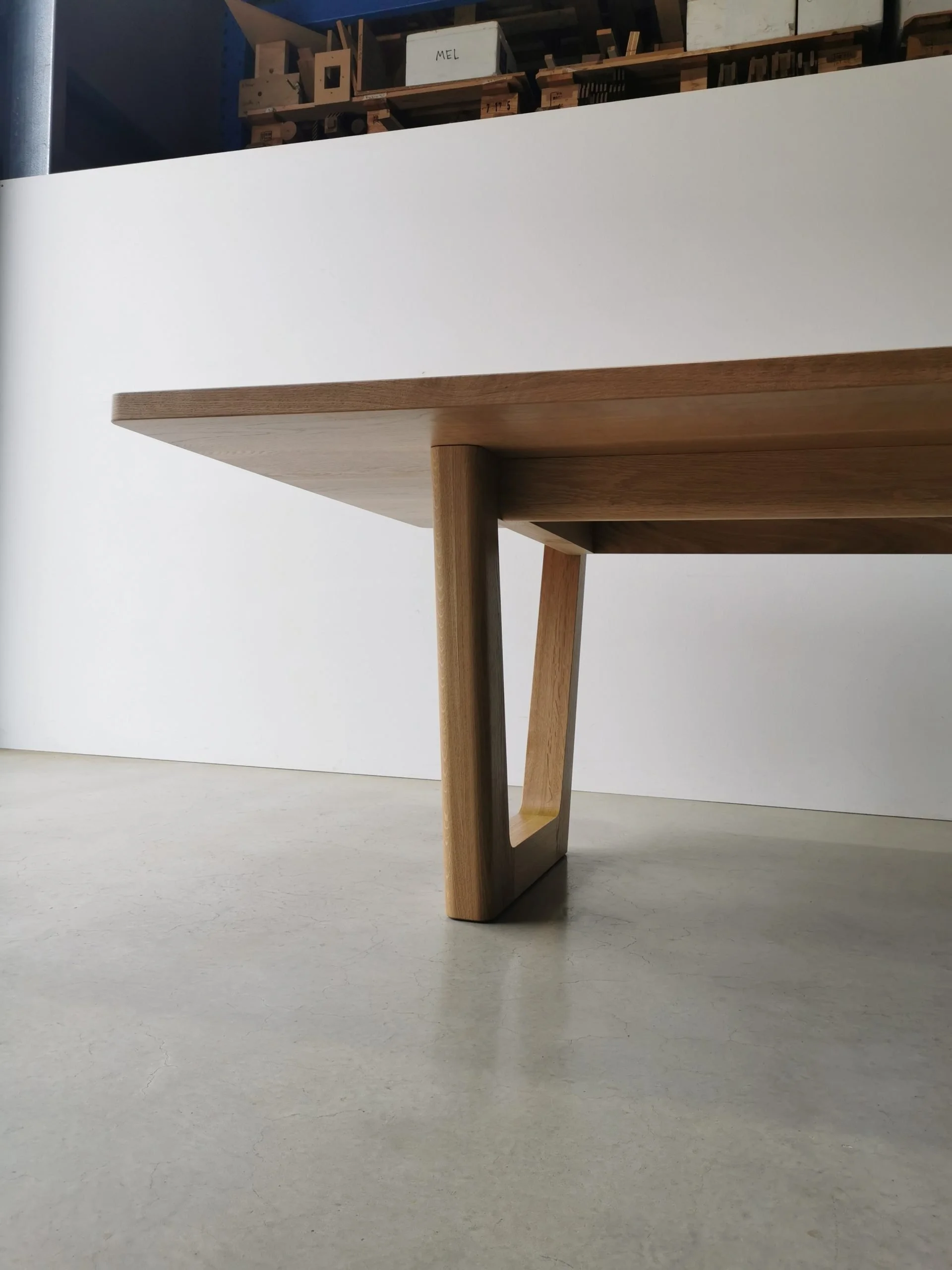 Close angled leg detail of Clairault Table in American Oak showing full trapezoidal frame joinery - bespoke furniture by Nathan Day Design