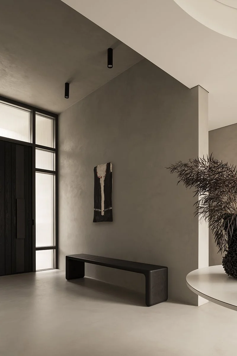 Hippo Bench in Ebonised Jarrah styled in a sculptural hallway with textural artwork and dark timber joinery - bespoke seating by Nathan Day Design