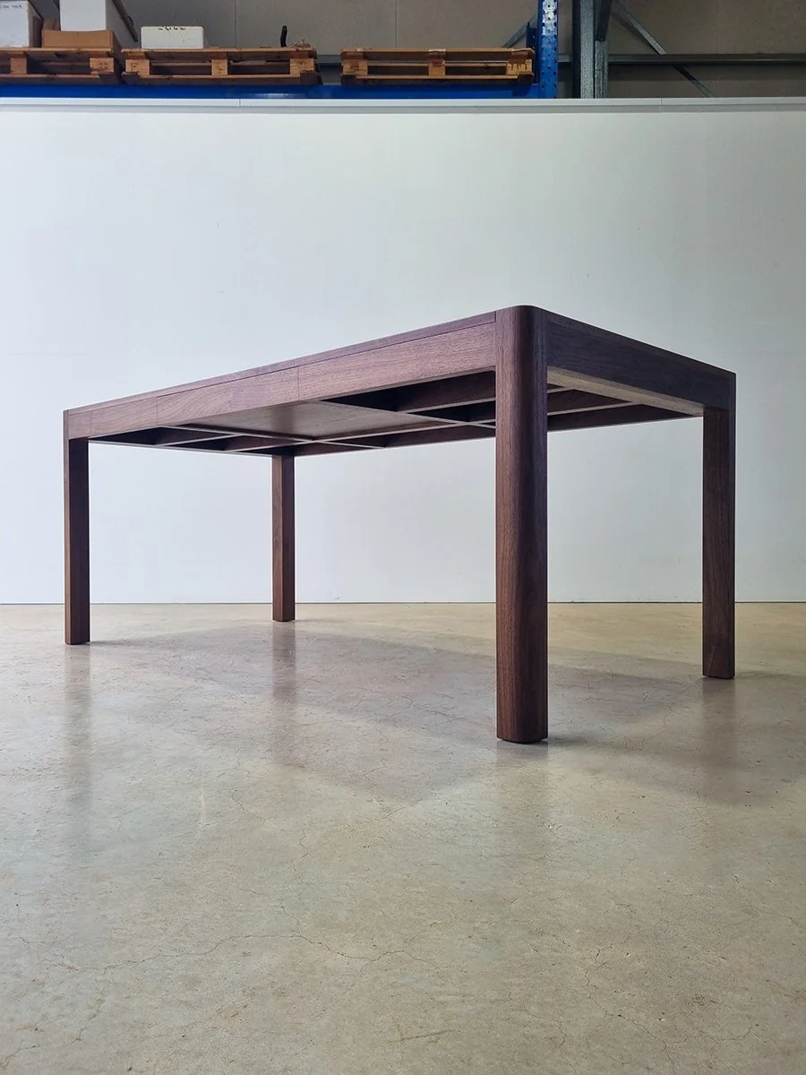 Irvine Desk in Walnut, minimalist frame-leg design - Nathan Day Design, full angled view in workshop setting