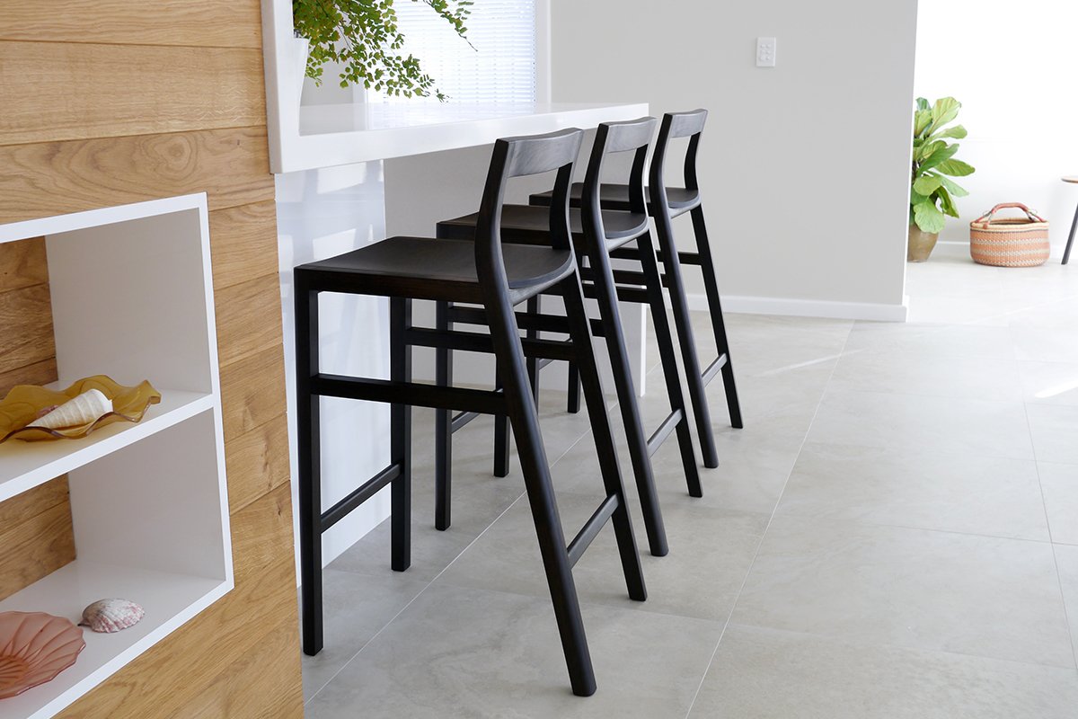 Low-back Bar Stools in ebonised Jarrah, pair shown in outdoor patio setting - Nathan Day Design