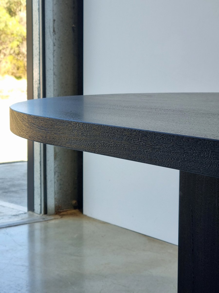 Detail of the Como Table's rounded end, showing the scorched and scrubbed edge texture in ancient Jarrah - Nathan Day Design