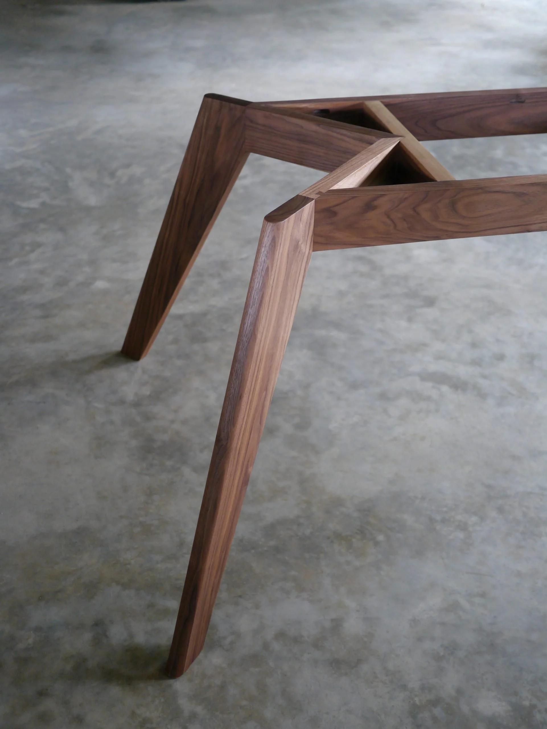 Underside view of Vista St Table's Walnut base showing the sliding dovetail joinery mechanism - bespoke furniture by Nathan Day Design