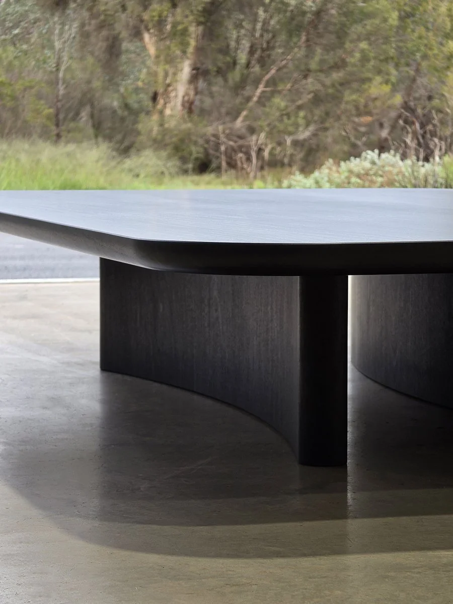 Prehistoric Coffee Table styled outdoors amid garden greenery near Dunsborough WA - bespoke ebonised jarrah furniture by Nathan Day Design