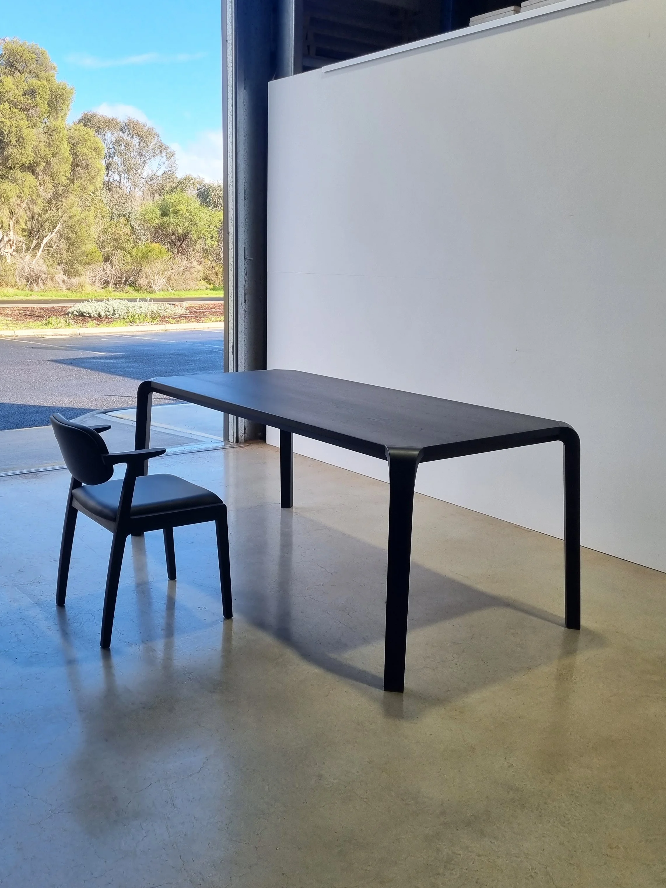 Araluen Desk in American and French Oak, ebonised finish variant with matching chairs, outdoor courtyard setting - Nathan Day Design