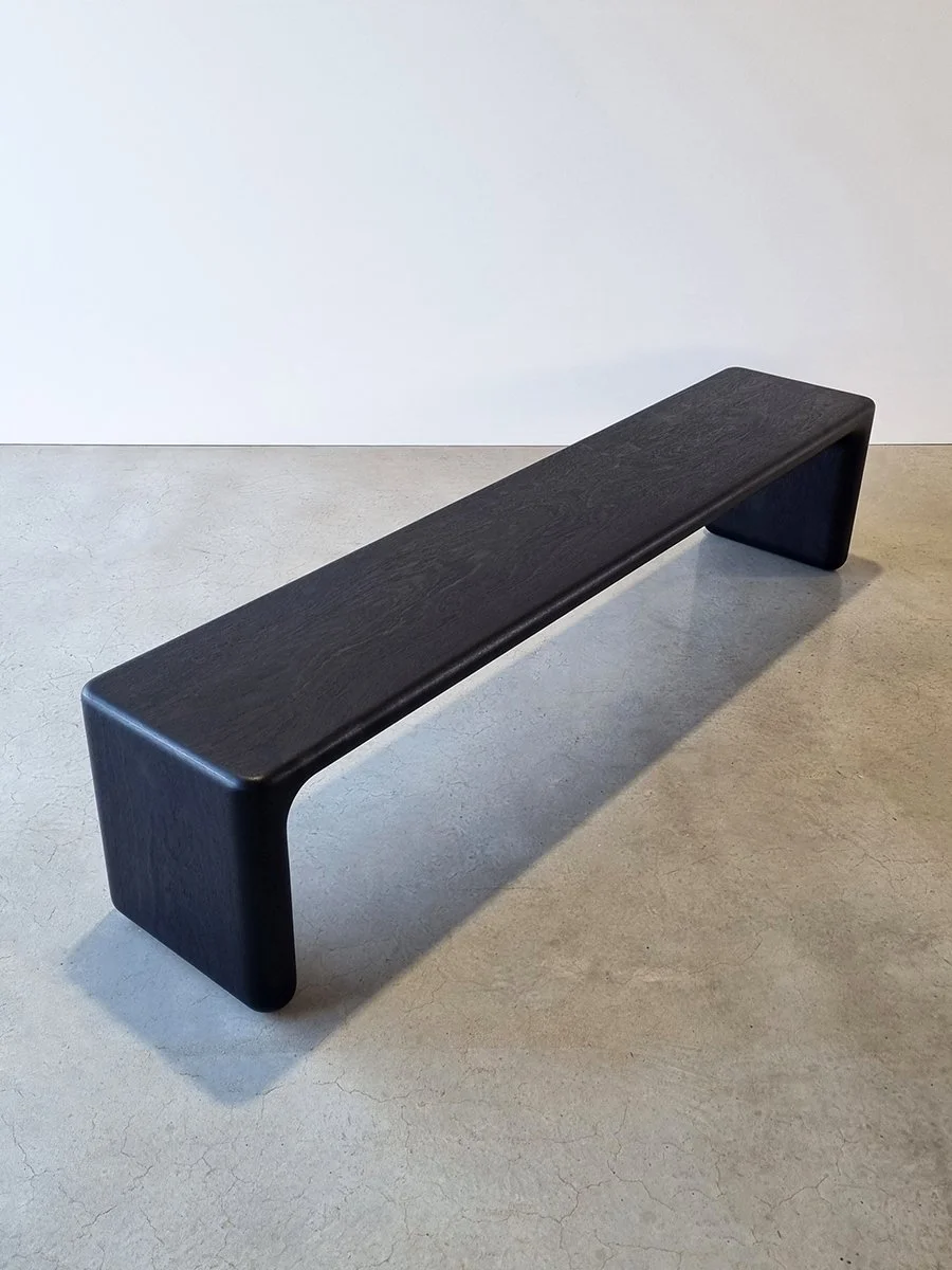 Hippo Bench in Ebonised Jarrah with squared-off angular legs, three-quarter view in plain studio setting - bespoke seating by Nathan Day Design
