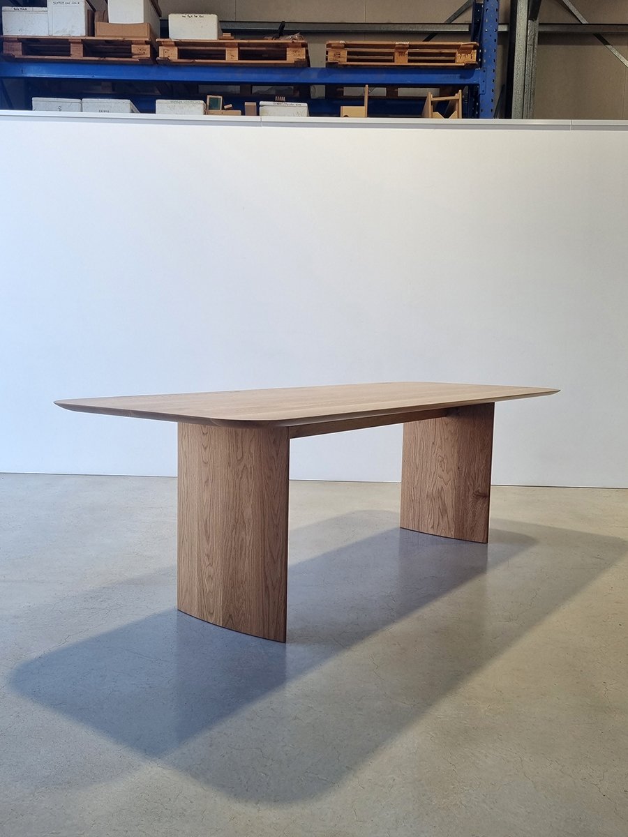 Angled workshop view of the Southern Ocean Table's minimalist slab-leg form in American Oak - Nathan Day Design