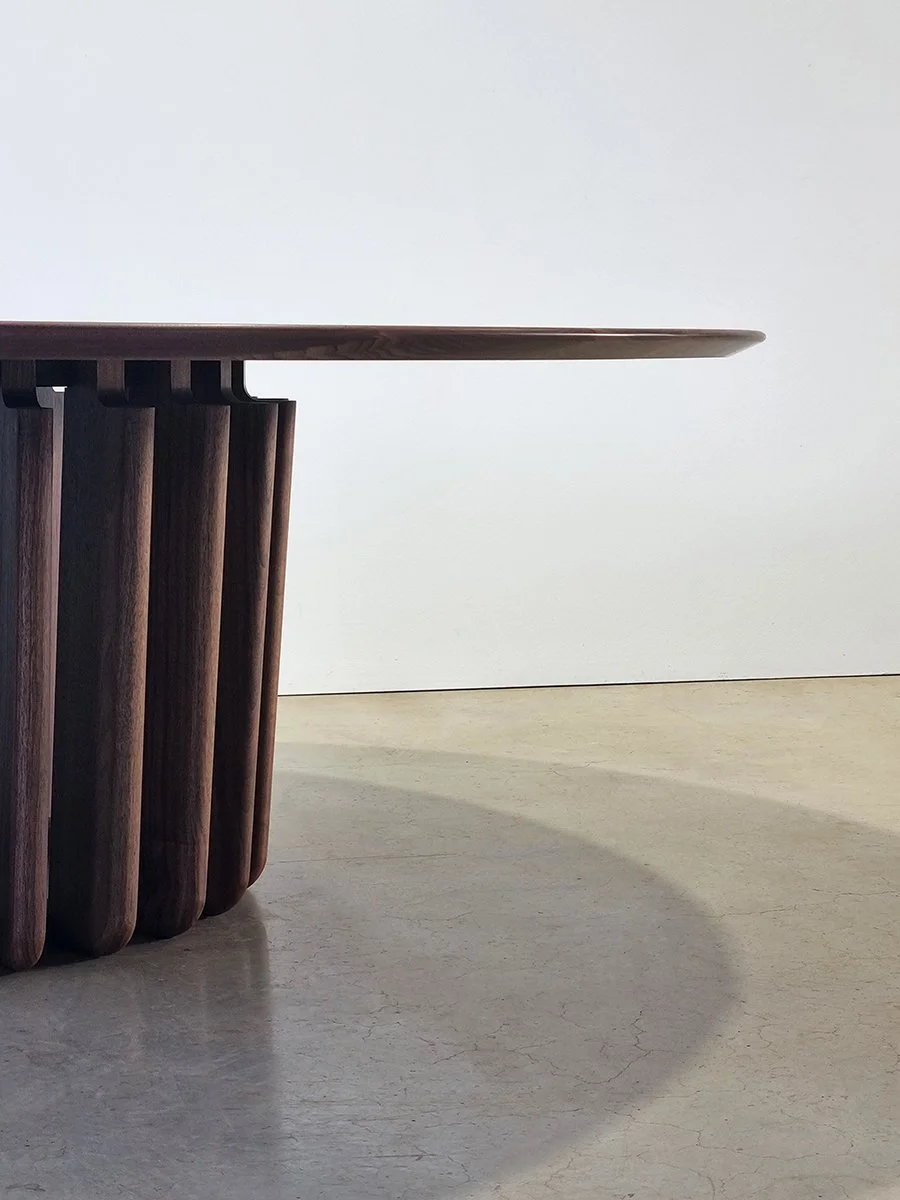 Low-angle view of the Lantern Table's thin bevelled top hovering above the fin cluster - Nathan Day Design