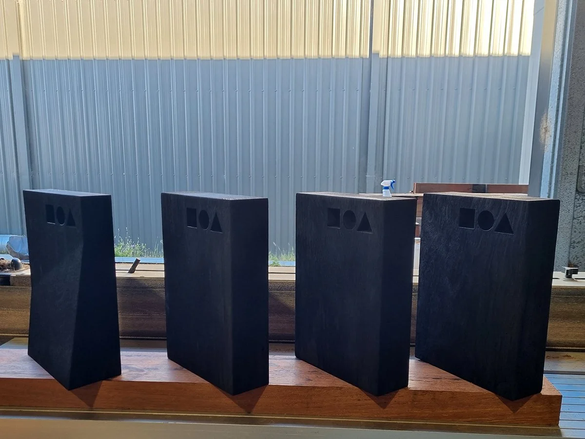 DIA Awards Trophies in scorched Jarrah - Nathan Day Design, full set of trophies lined up together indoors