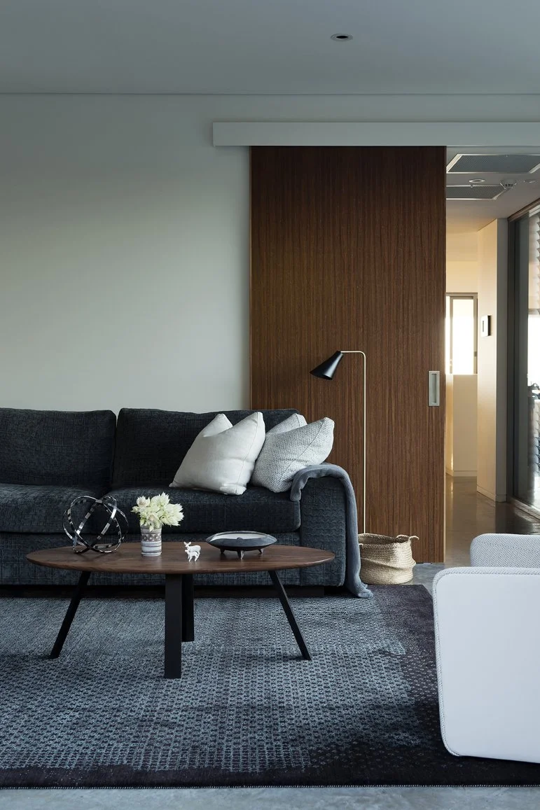 Over the Falls Coffee Table in Walnut, styled in a contemporary lounge setting - bespoke furniture by Nathan Day Design