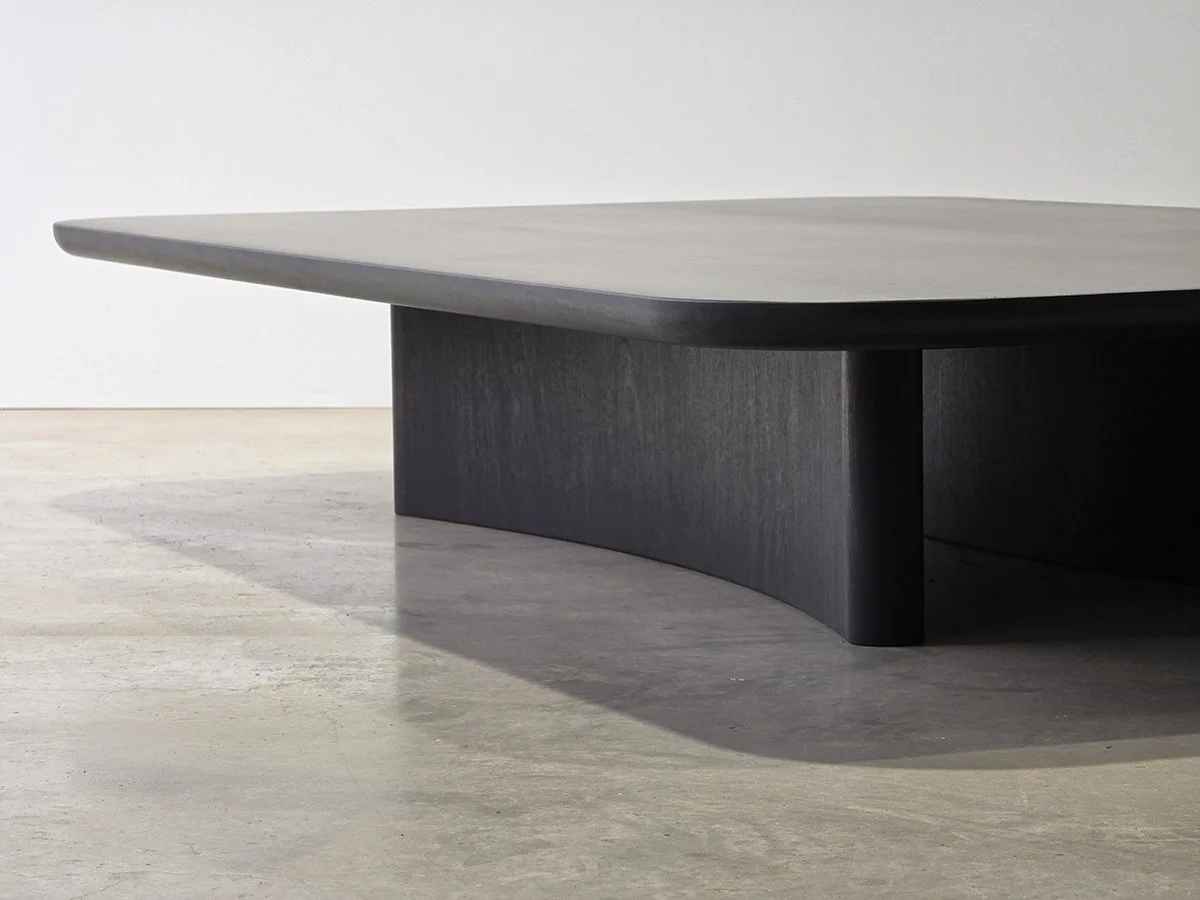 Prehistoric Coffee Table angled view showing the monolithic curved leg base - handcrafted ebonised jarrah coffee table, Nathan Day Design