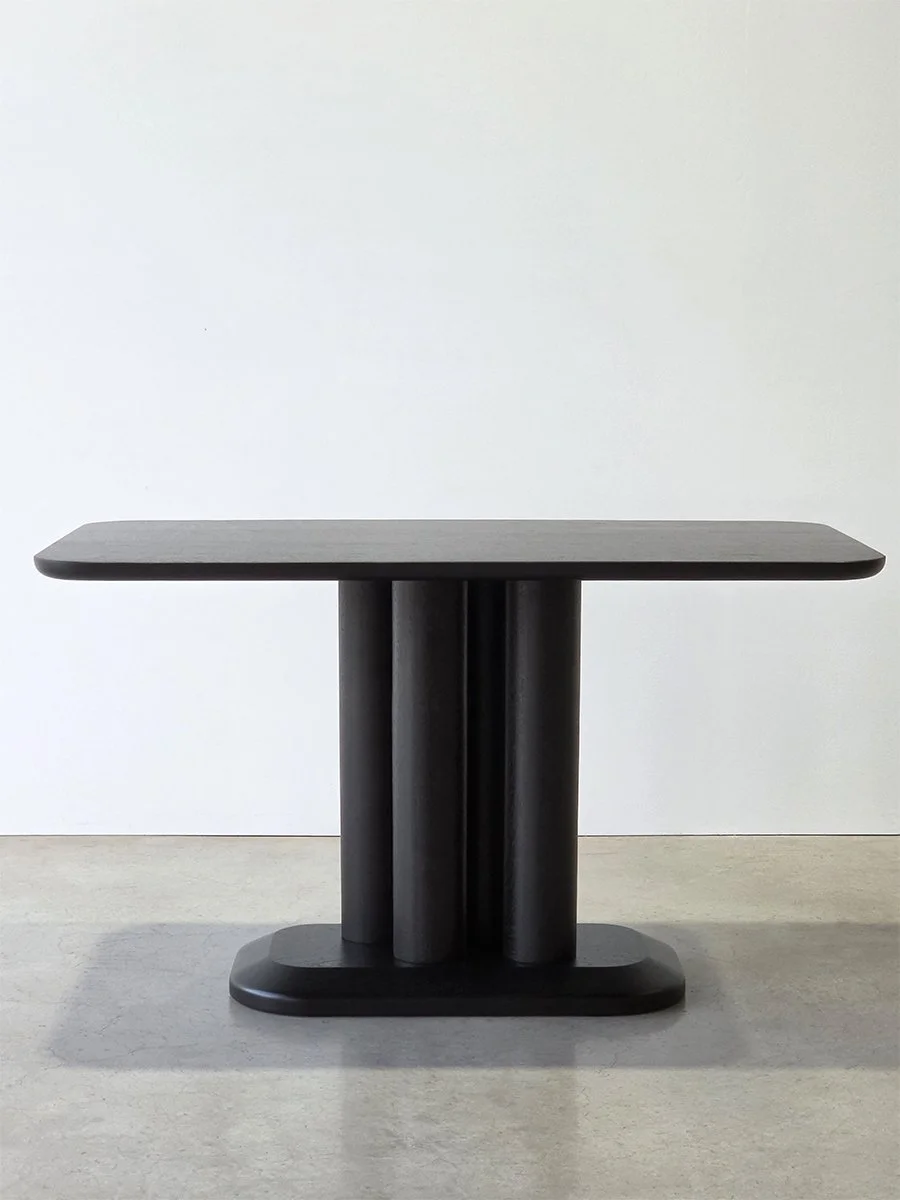 Straight-on view of the Coop Nook Table's three cylindrical ebonised Walnut legs - Nathan Day Design