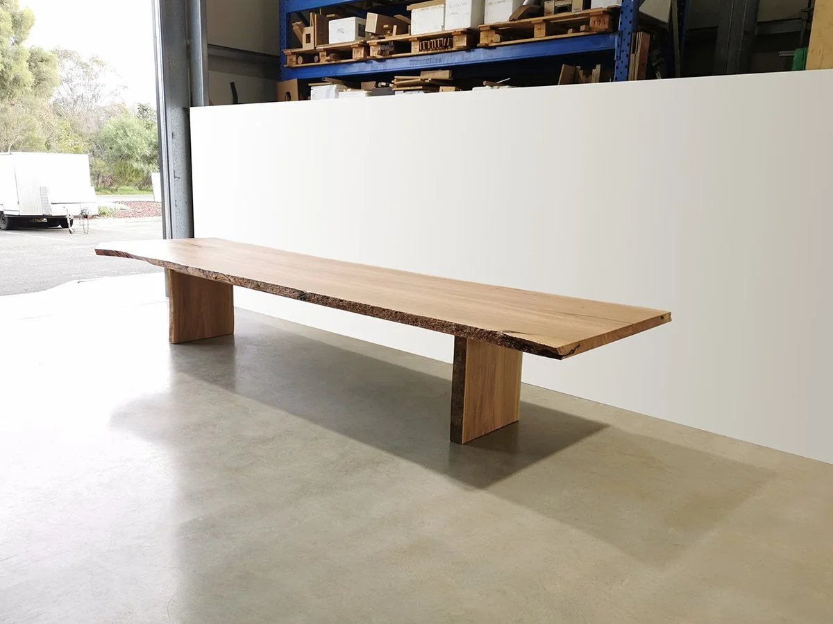 Long single-slab live edge dining table in Marri with plank leg supports, workshop doorway setting - bespoke furniture by Nathan Day Design