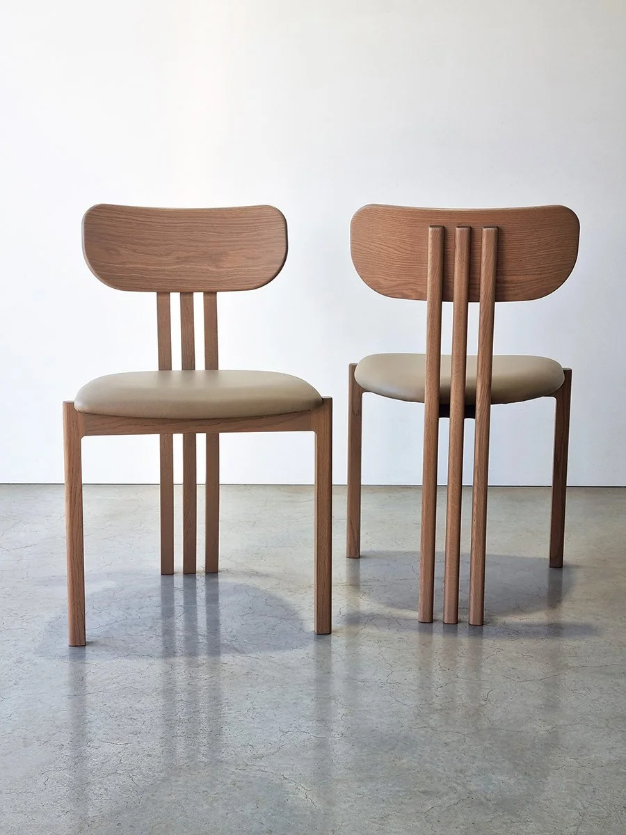 Pair of custom slat-back dining chairs in timber with cream upholstered seats, designed to accompany the Pebble Table - Nathan Day Design