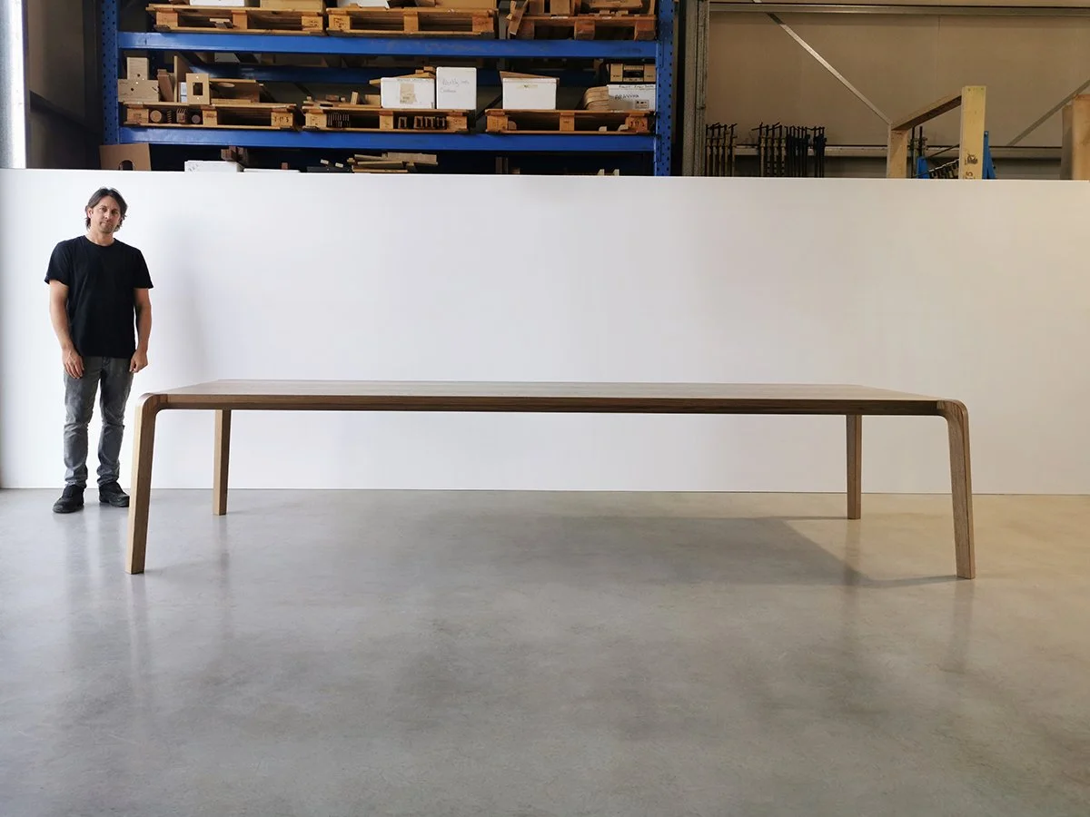 Nathan Day standing beside the finished Araluen Table in his Dunsborough workshop, showing its 4 metre scale