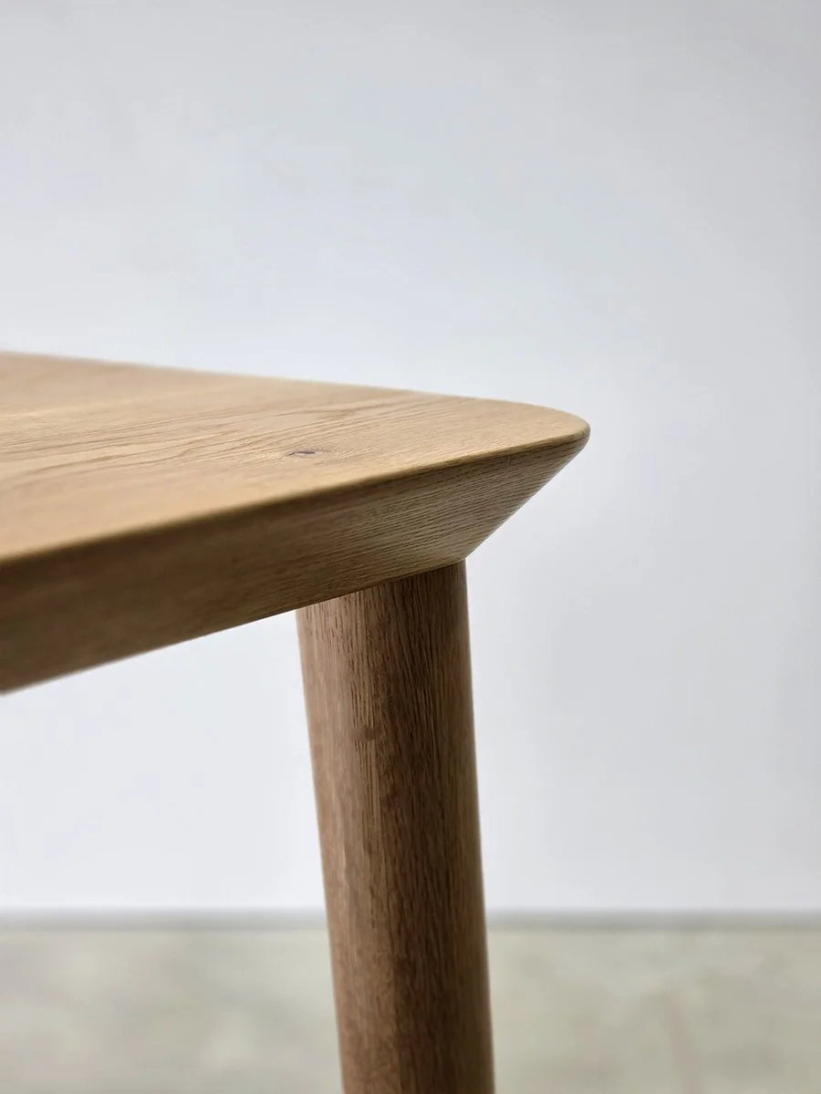Close-up angled detail of Mercator Way Table edge and tapered leg in American Oak, highlighting timber grain and craftsmanship - bespoke furniture by Nathan Day Design