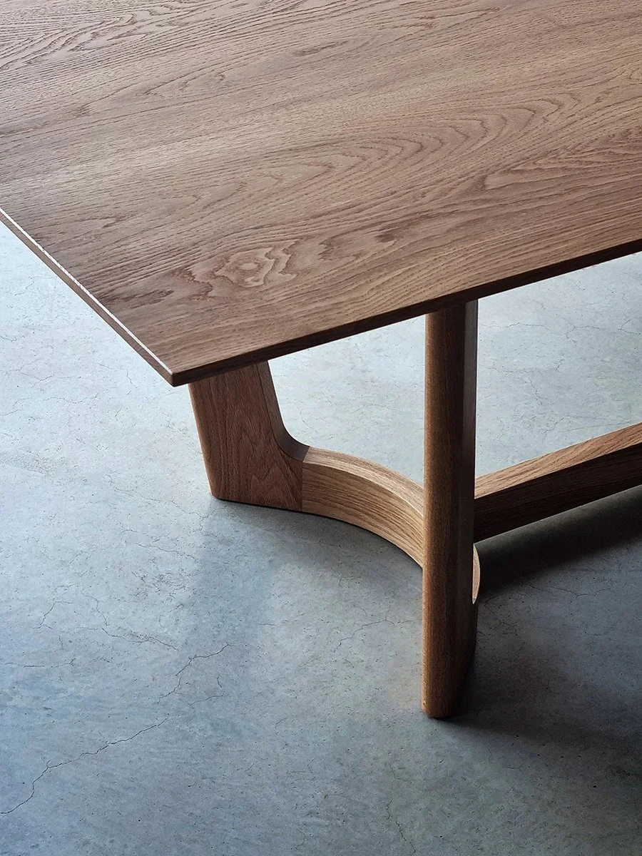 Overhead detail of the Froxfield Table's curved rail and Hay Rake-inspired joinery in Walnut - Nathan Day Design