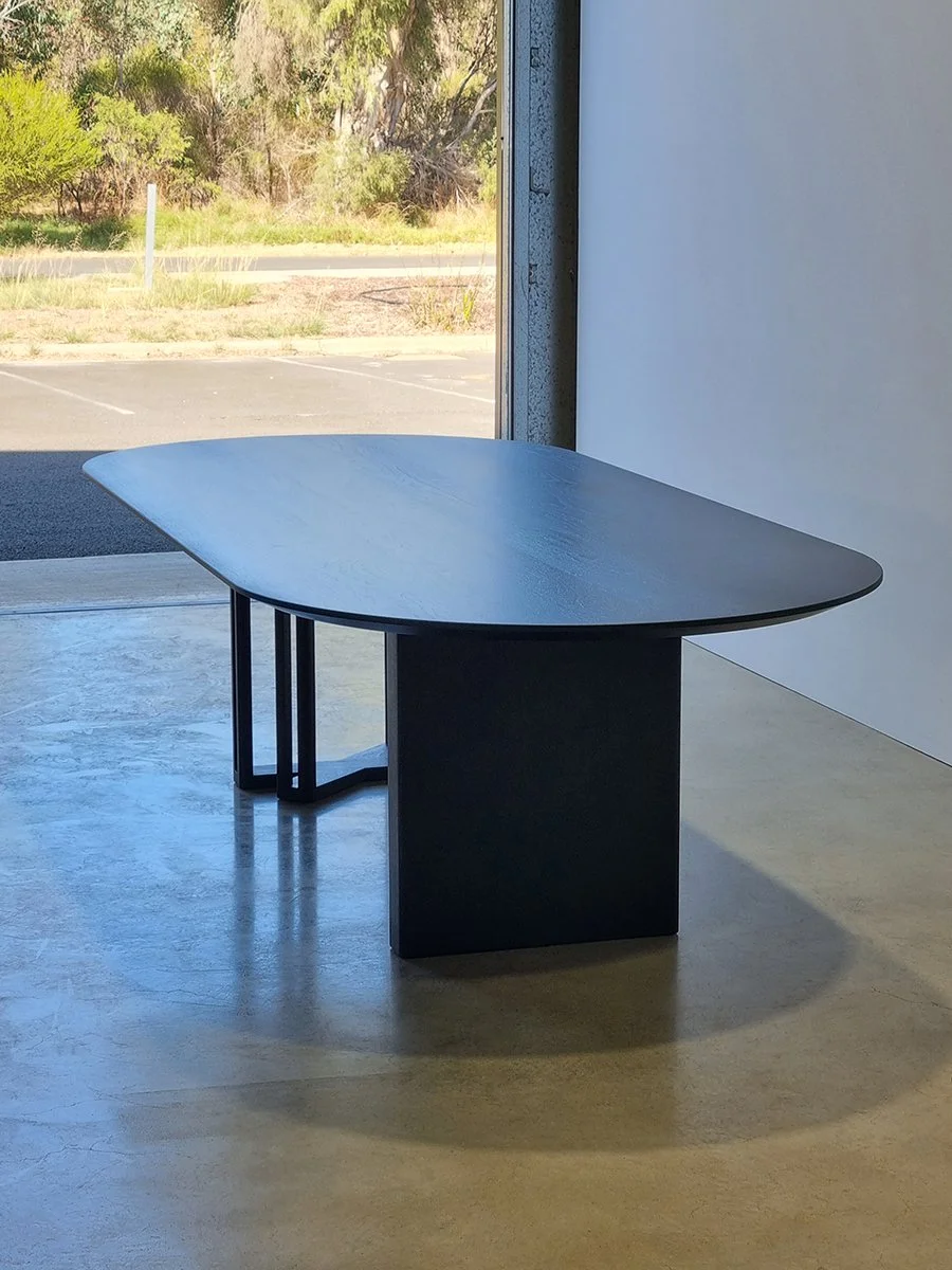Giacci Table's bevelled Walnut top catching natural light near the workshop's open doorway - Nathan Day Design