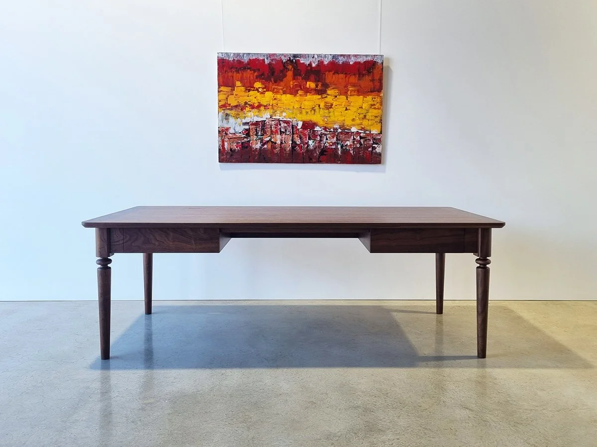 Boundary Lane Desk in American Walnut, full front view with abstract artwork backdrop - Nathan Day Design