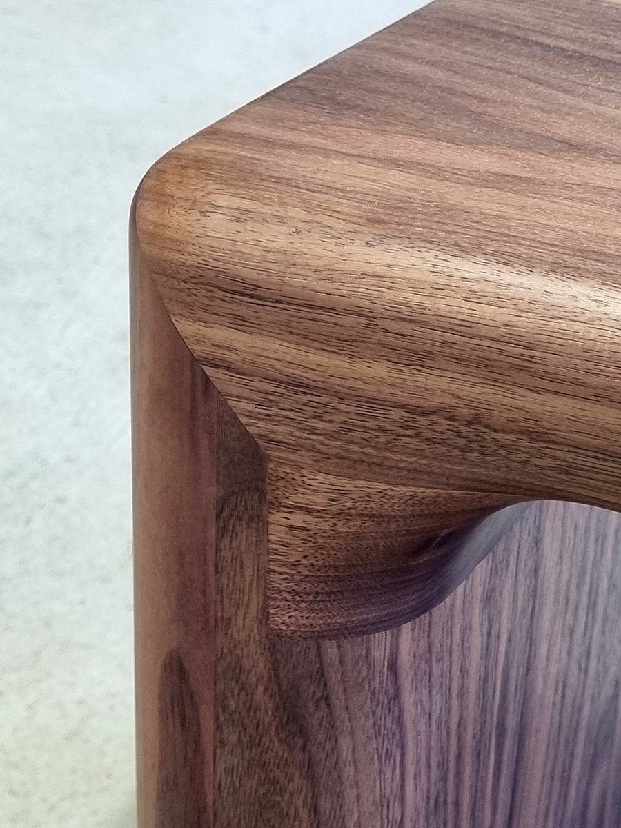 Close-up of Hippo Bench's rounded corner in Walnut showing seamless waterfall grain matching - bespoke seating by Nathan Day Design