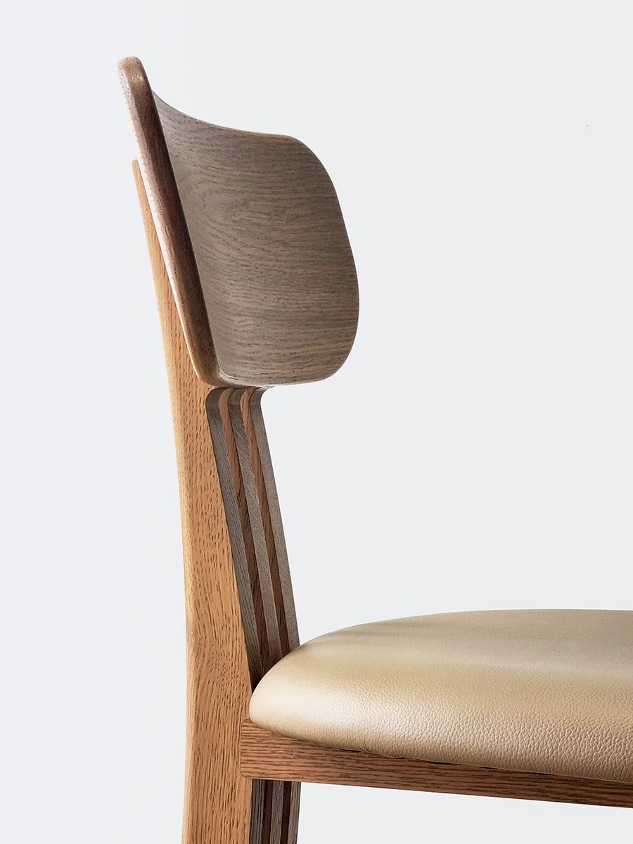 Tulip Chair in American Oak with tan leather seat, side profile close-up showing curved backrest and vertical slat joinery - Nathan Day Design bespoke furniture