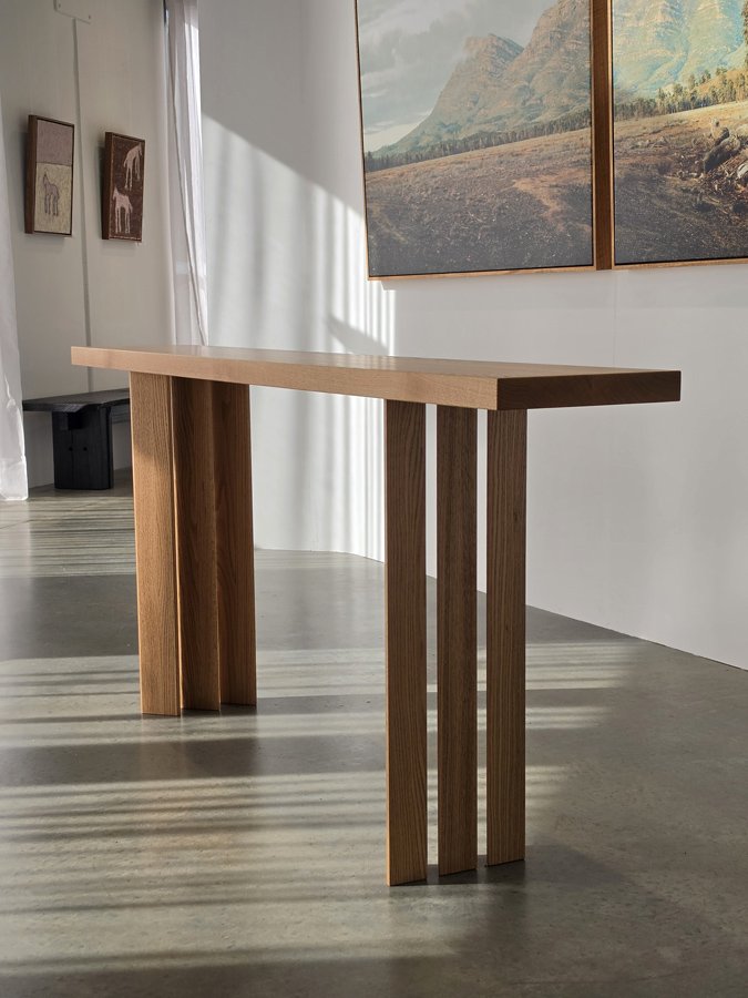 Prism Console in Red Oak, front angled view in gallery lifestyle setting - Nathan Day Design