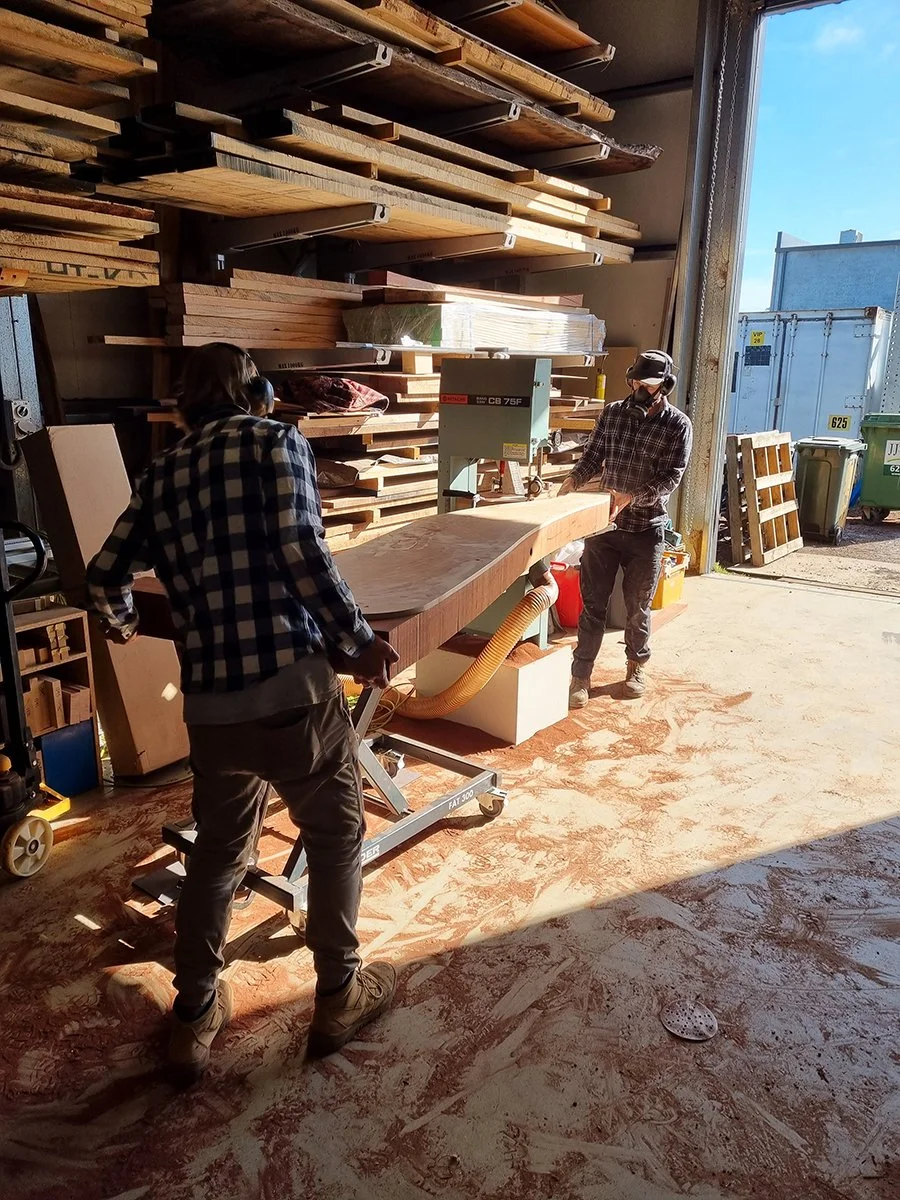 Reception Counter - One The Esplanade in scorched timber - Nathan Day Design, maker working in workshop surrounded by raw timber stock