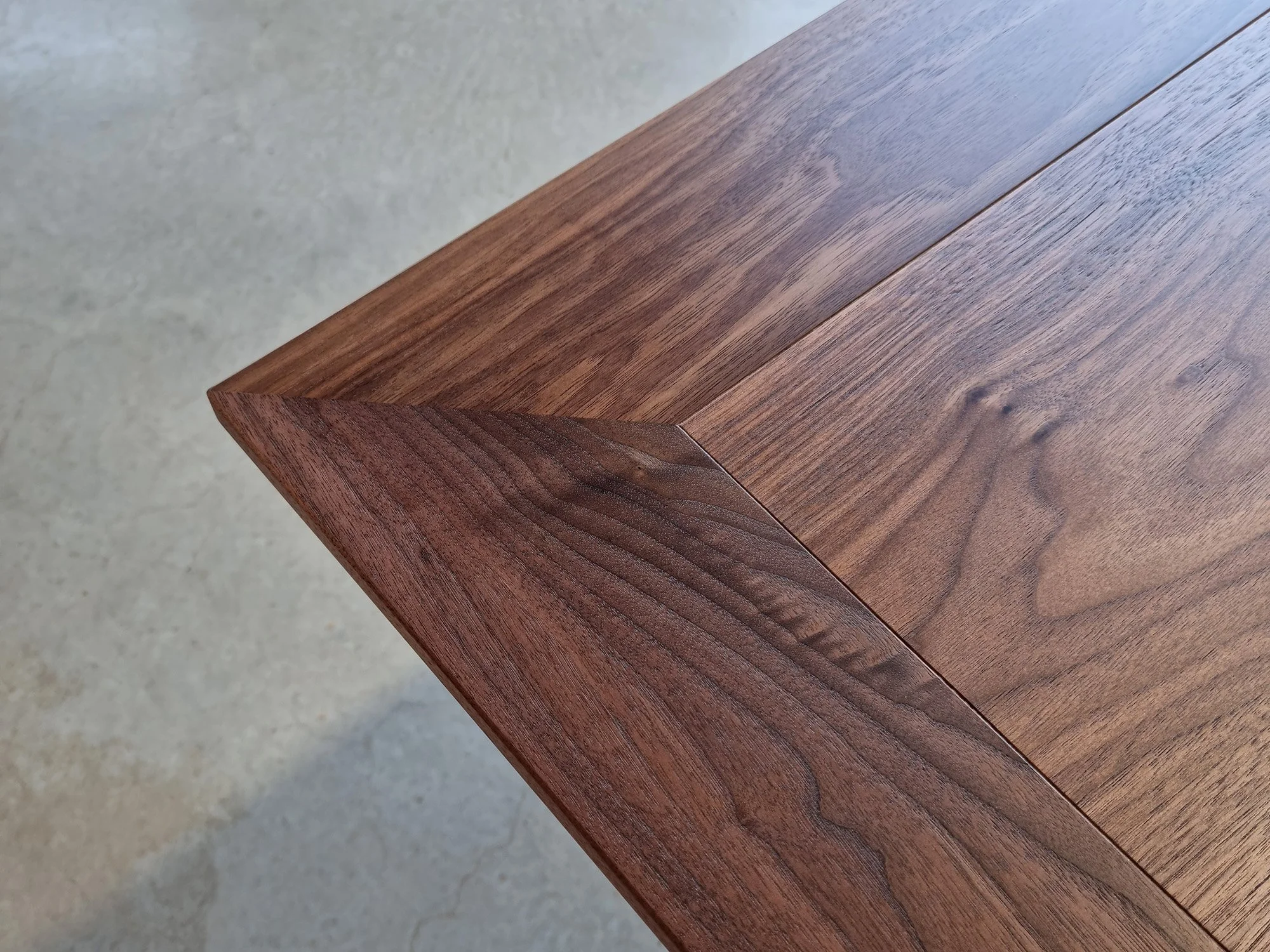 Close-up of Botanical Table's mitred corner joint in Walnut, showing book-matched timber grain - bespoke furniture by Nathan Day Design