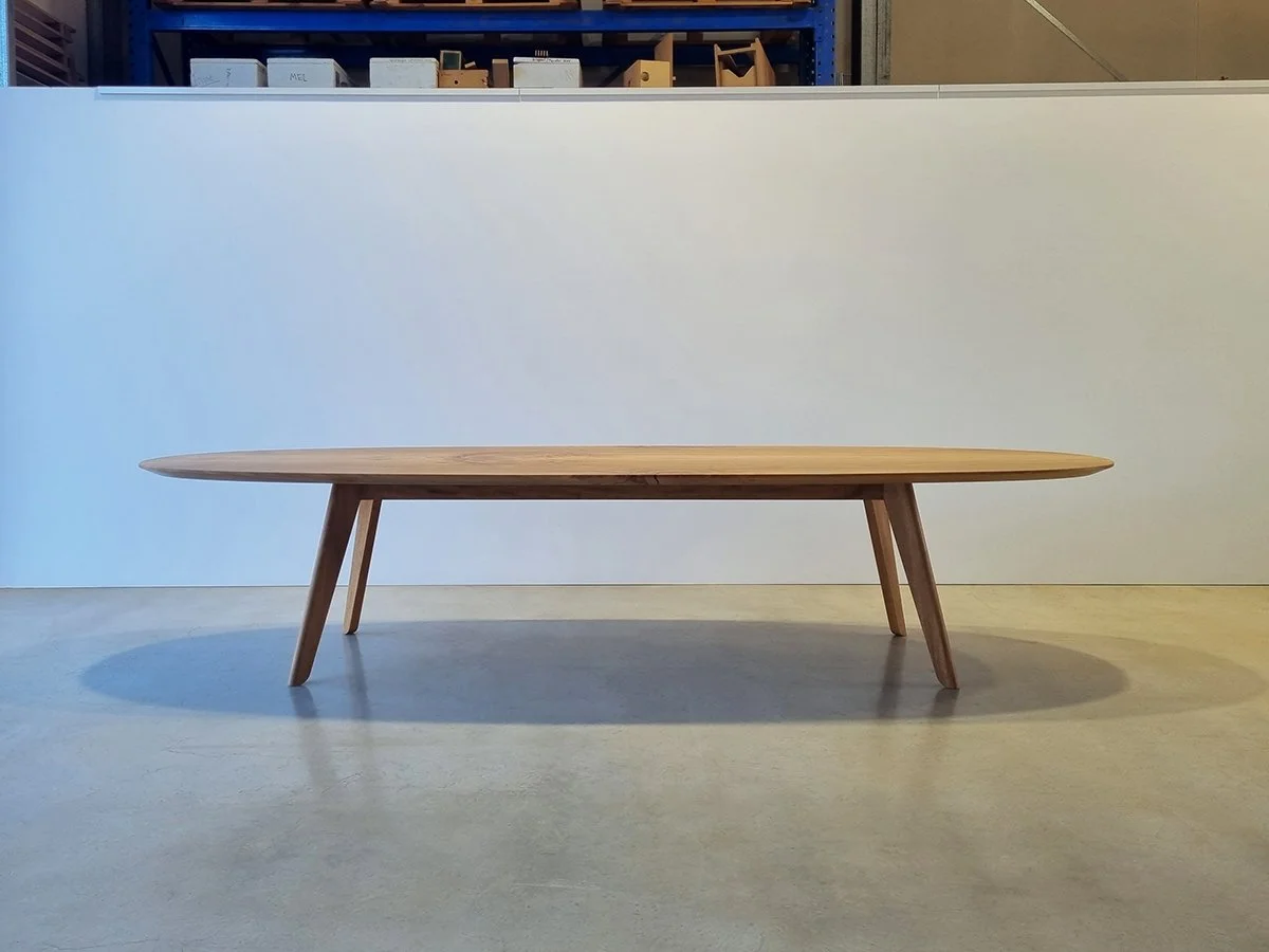 Front-on side profile of Peppy Grove Table in Oak showing signature bevelled edge, workshop setting - bespoke furniture by Nathan Day Design