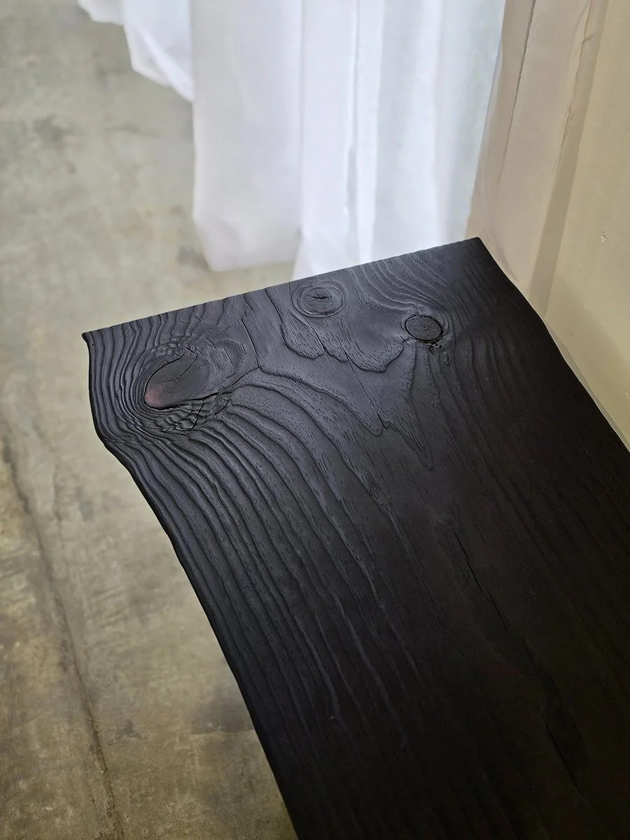 Close-up detail of Burnside Bench's scorched textured grain and natural knot holes at the end of the slab - bespoke seating by Nathan Day Design
