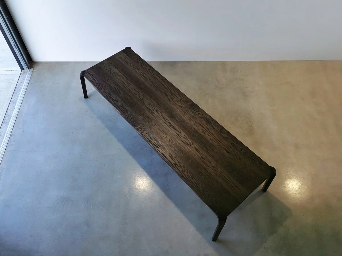 Overhead view of the Araluen Table in ebonised American Oak, full cambered span in an architectural interior - Nathan Day Design