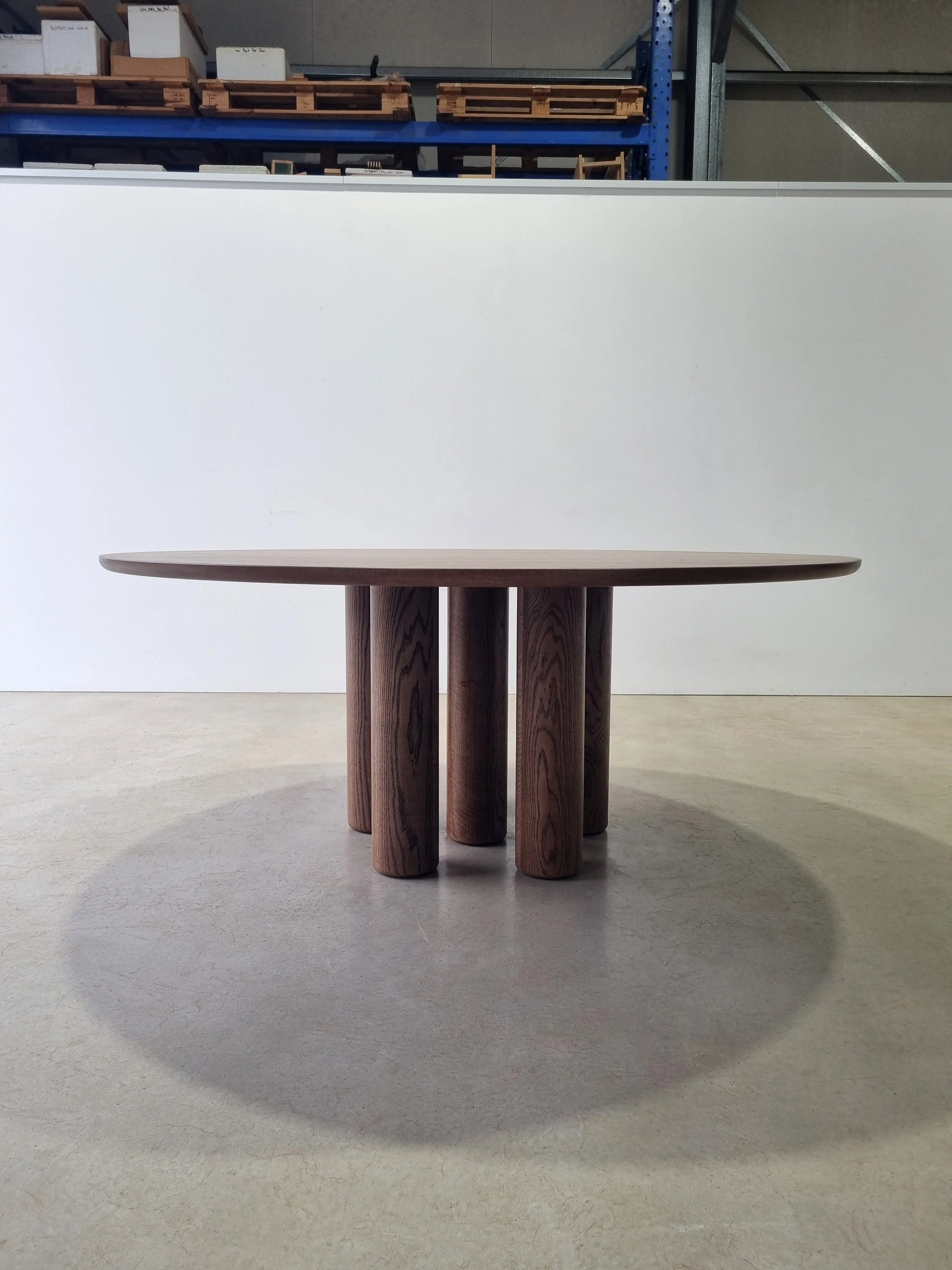 Front-on view of Anemone Table in tinted American Oak showing the column legs aligned to appear as fewer, wider supports - bespoke furniture by Nathan Day Design