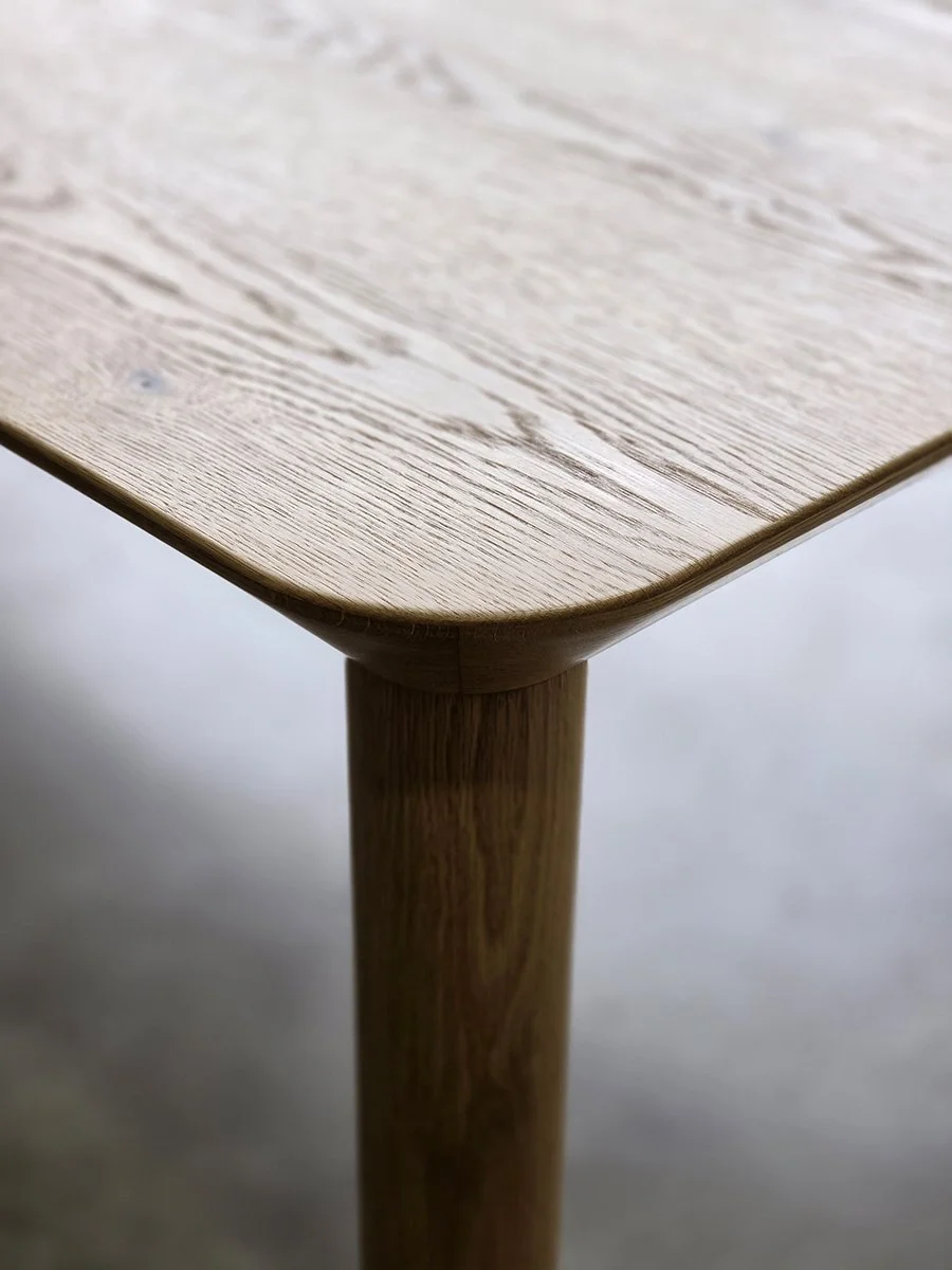 Close-up detail of Mercator Way Table corner joinery in American Oak, showing timber grain and tapered leg construction - bespoke furniture by Nathan Day Design