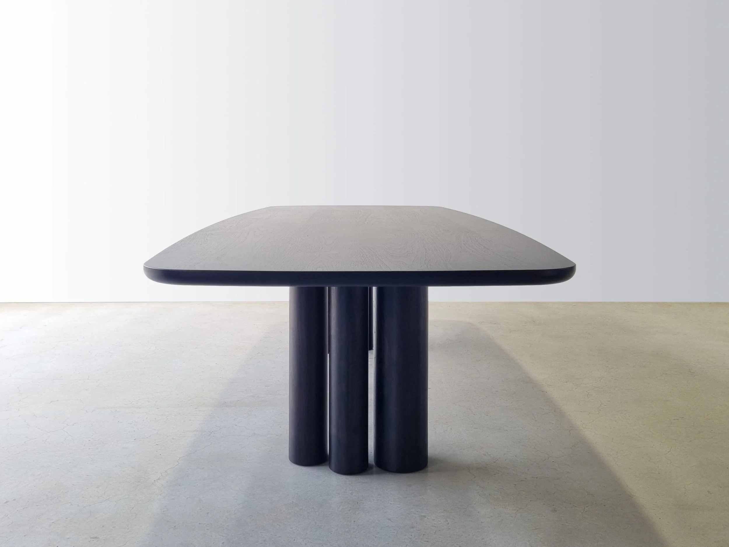 End-on view of Column Table in Ebonised Walnut showing the sculptural negative spaces between column legs - bespoke furniture by Nathan Day Design