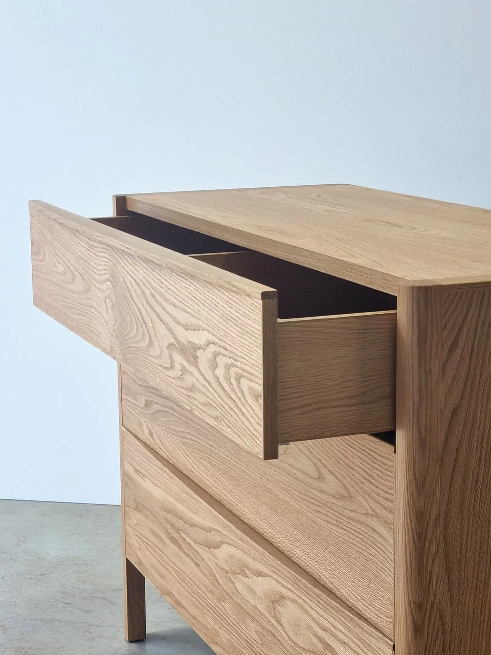 Hampden Chest of Drawers in American Oak - Nathan Day Design, angled view with top drawer open