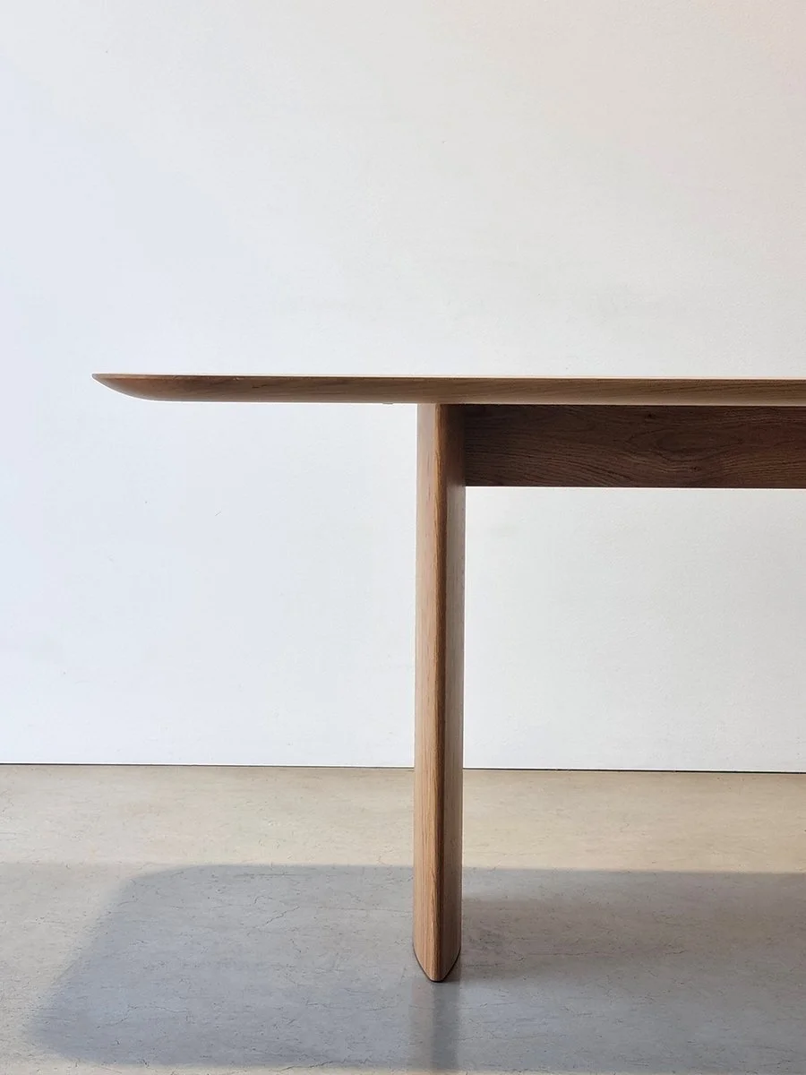 Detail of the Southern Ocean Table's subtly curved top edge and slender American Oak leg - Nathan Day Design