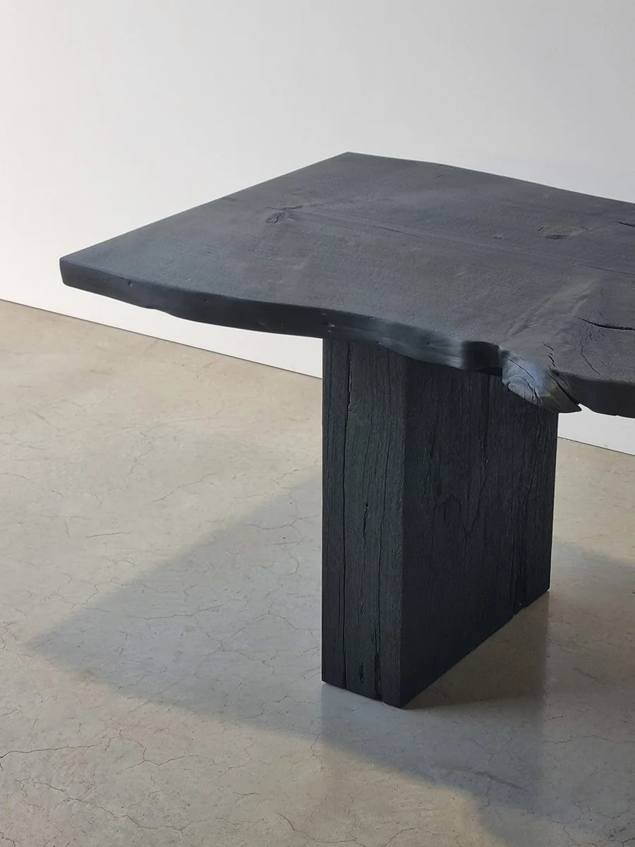 Close angled view of Burnside Bench showing the natural undulating live edge and scorched slab leg - bespoke seating by Nathan Day Design