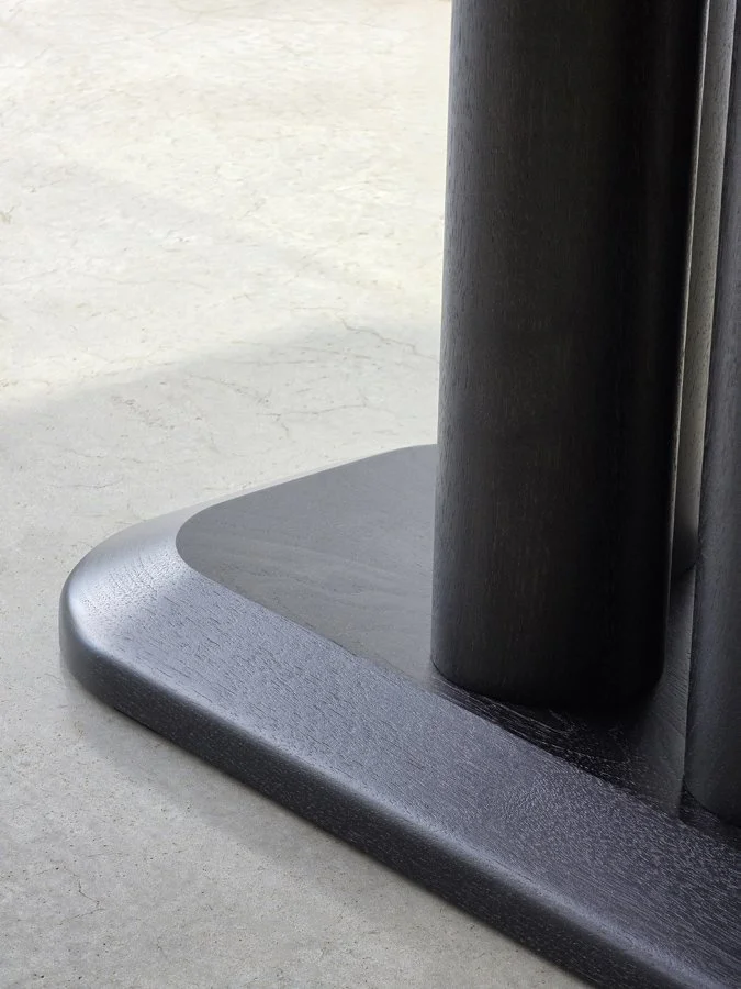 Close-up of the Coop Nook Table's base plinth where the cylindrical legs meet the rounded foot - Nathan Day Design