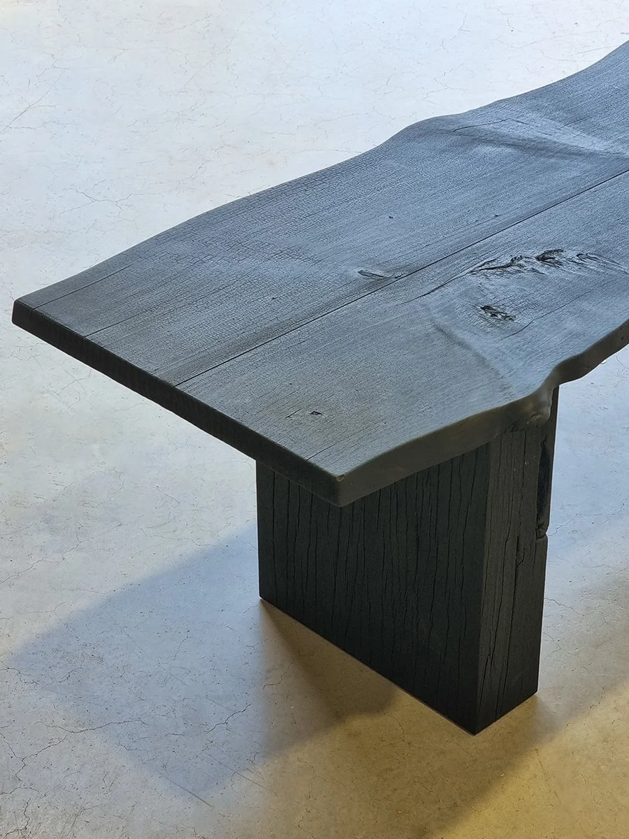 Elevated angled view of Burnside Bench showing the tapered slab end and mortise leg joinery in scorched timber - bespoke seating by Nathan Day Design