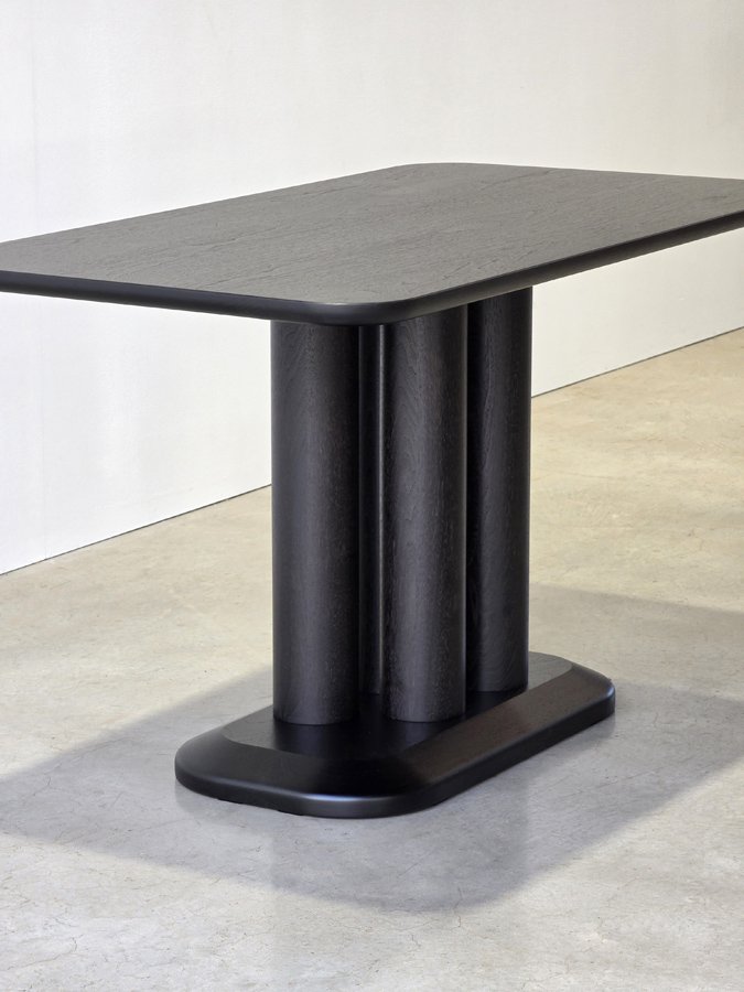 Three-quarter angled view of the Coop Nook Table revealing all three offset legs, bright studio setting - Nathan Day Design