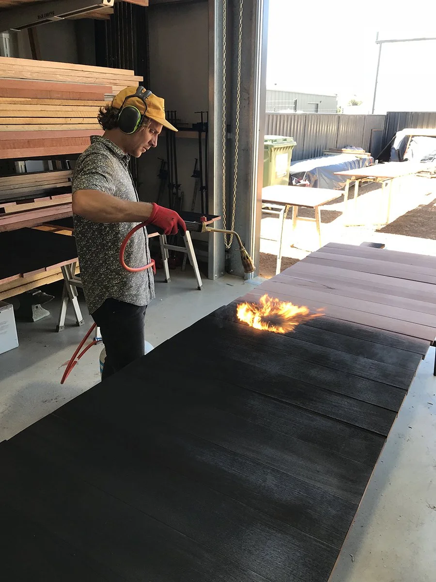 DWER custom furniture in WA Blackbutt - Nathan Day Design, maker torching black tabletop finish in workshop