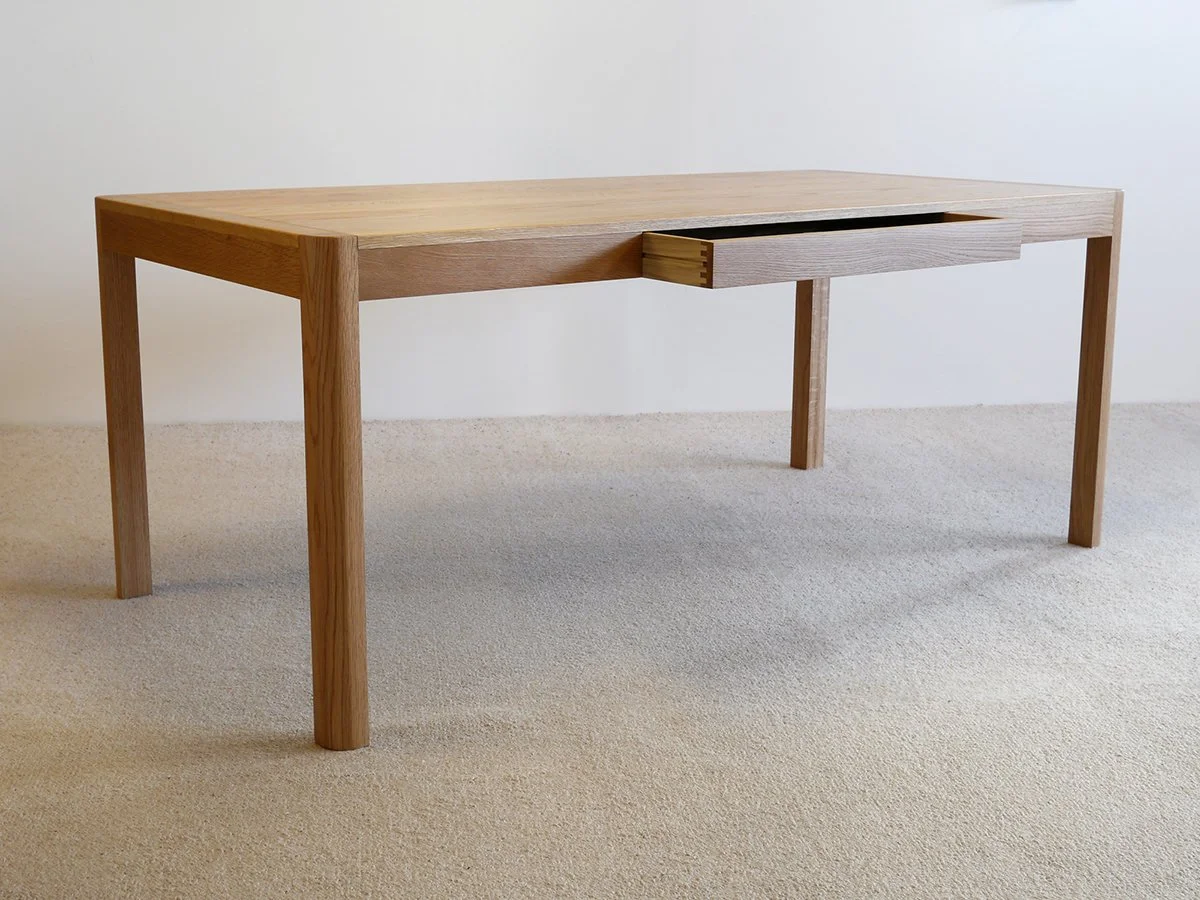 Irvine Desk in Walnut, minimalist frame-leg design - Nathan Day Design, angled lifestyle view of light Oak finish variant
