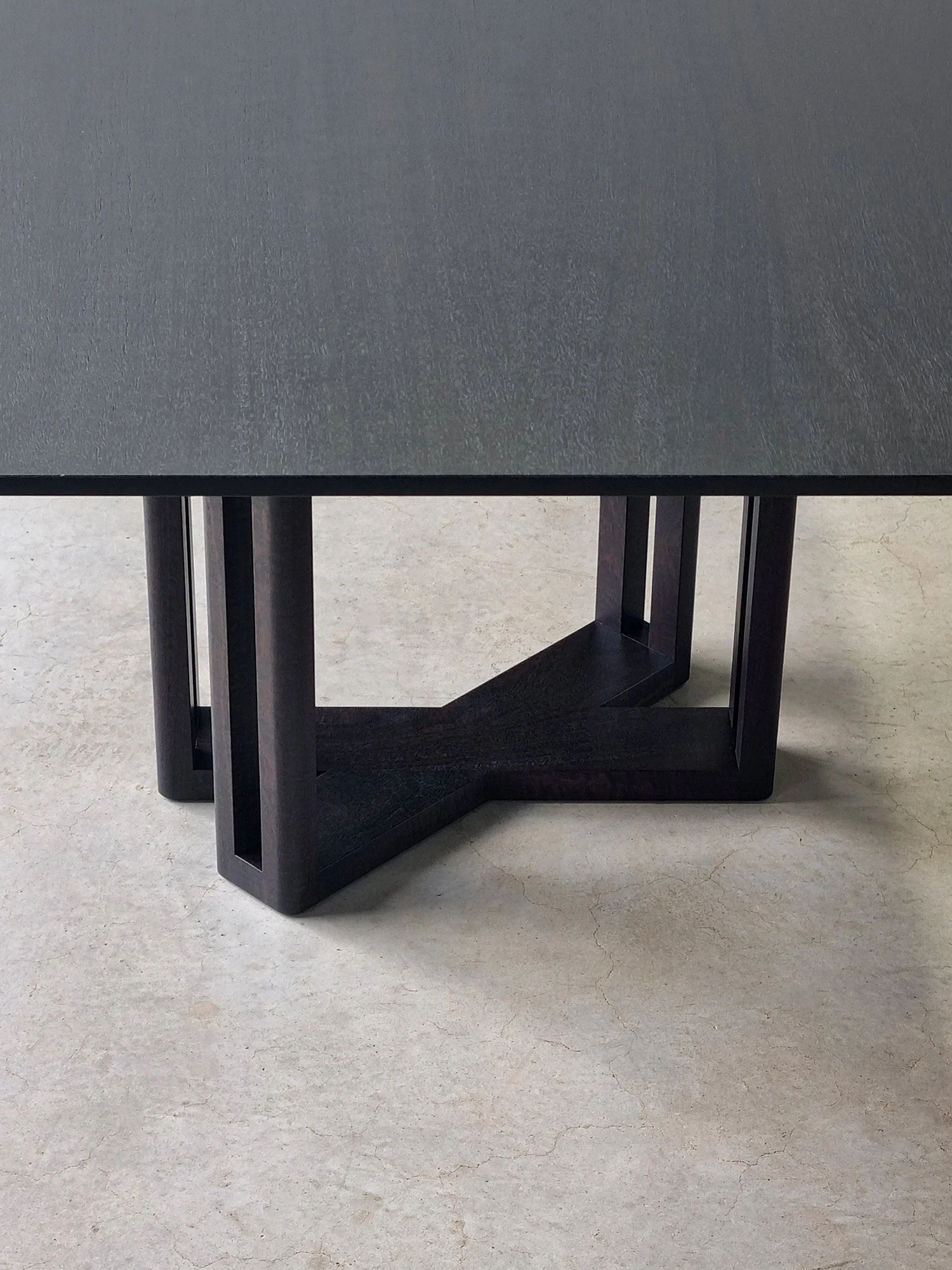 Detail of the Giacci Table's sculptural underside base converging into a Y-shaped frame - Nathan Day Design