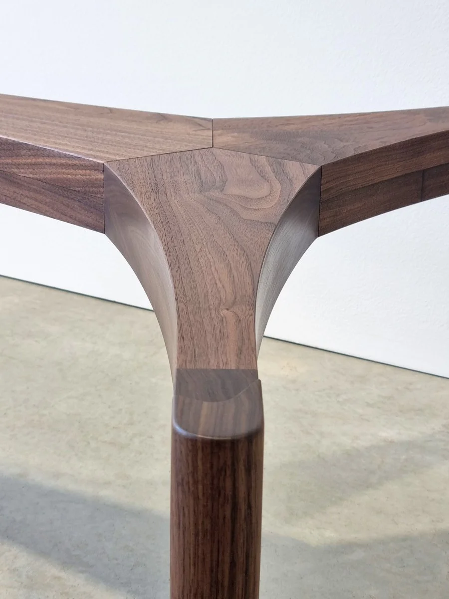 Top-down detail of the Wende Coffee Table's sculpted American Walnut leg joinery - bespoke furniture by Nathan Day Design