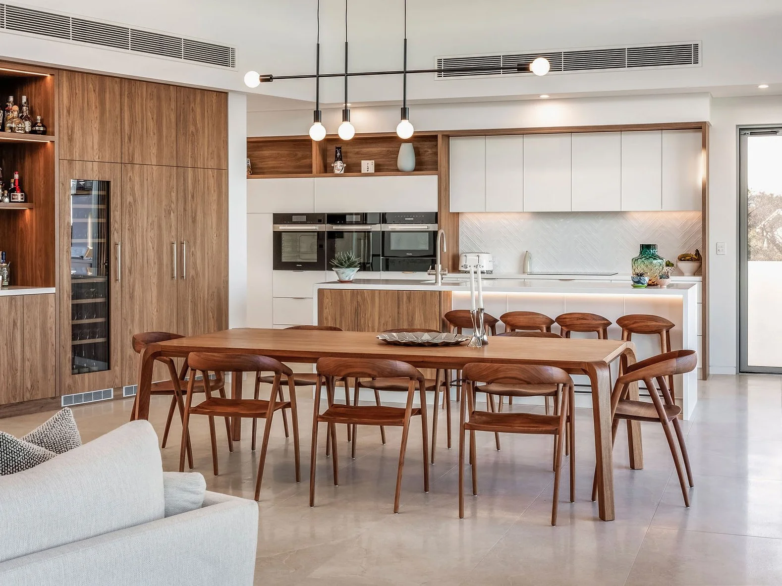 Araluen Table in Walnut, full dining setting in an open-plan coastal home kitchen - Nathan Day Design
