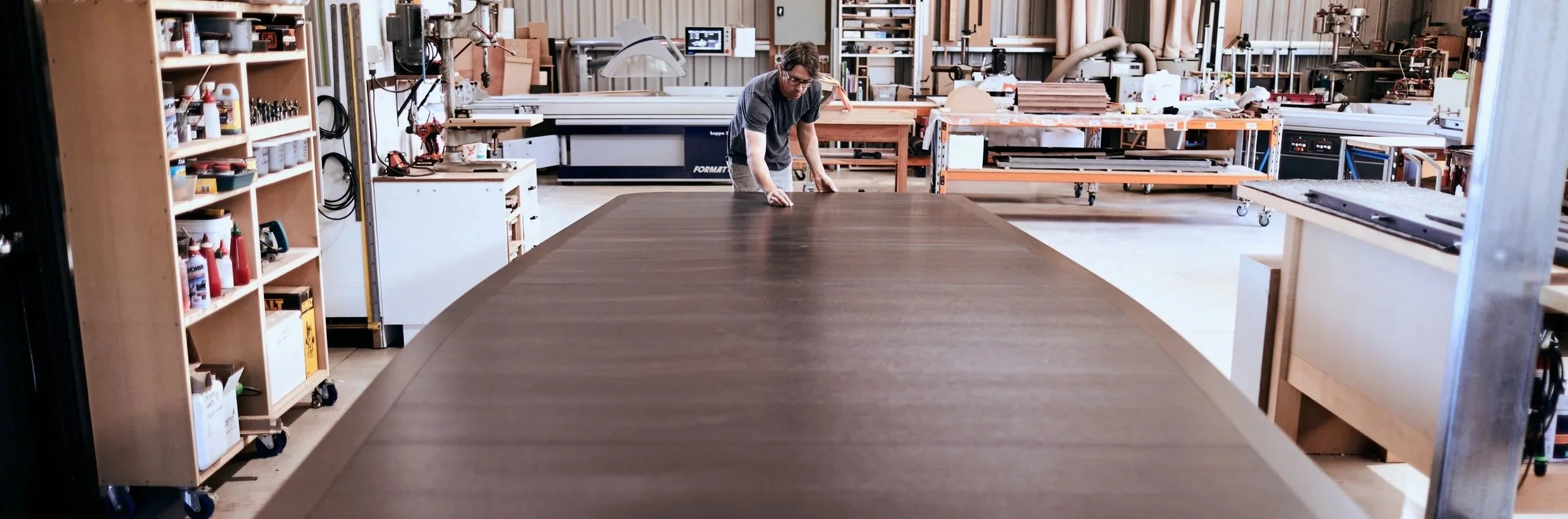 Nathan Day at work on a large timber table in the Nathan Day Design workshop in Western Australia.
